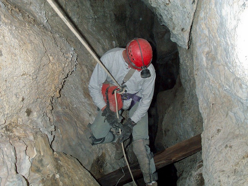 Jon Jasper rappeling pass the historic ladder in Middle Cave.